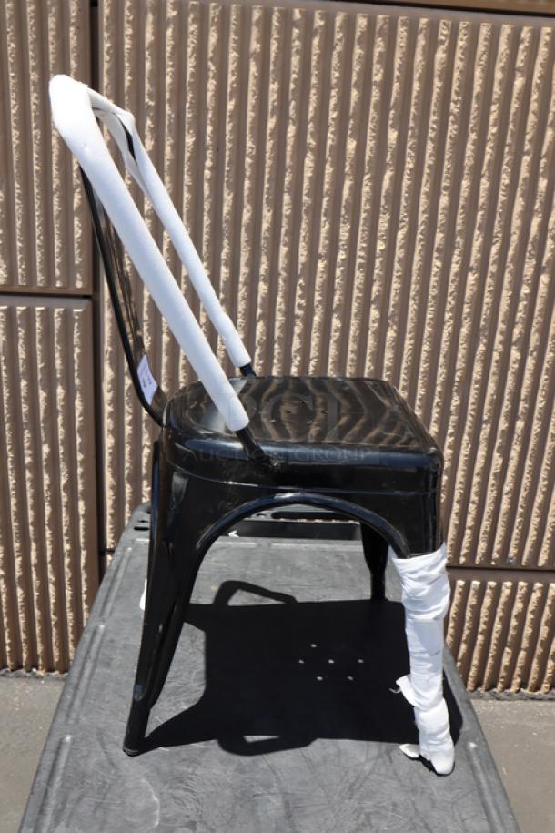 Lancaster Table & Seating Alloy Onyx Black Outdoor Cafe Chair, model 164CMCAFEBLK, with minor scuffs and scratches.