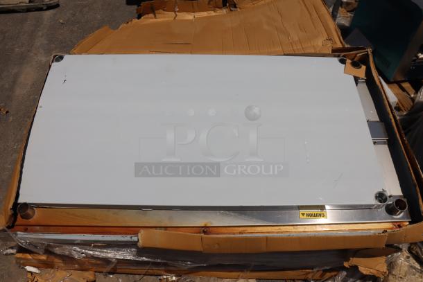Regency 600TSB3660S stainless steel work table, 36"x60", with 4" backsplash, undershelf. Scratch-n-dent condition. Caution label visible.