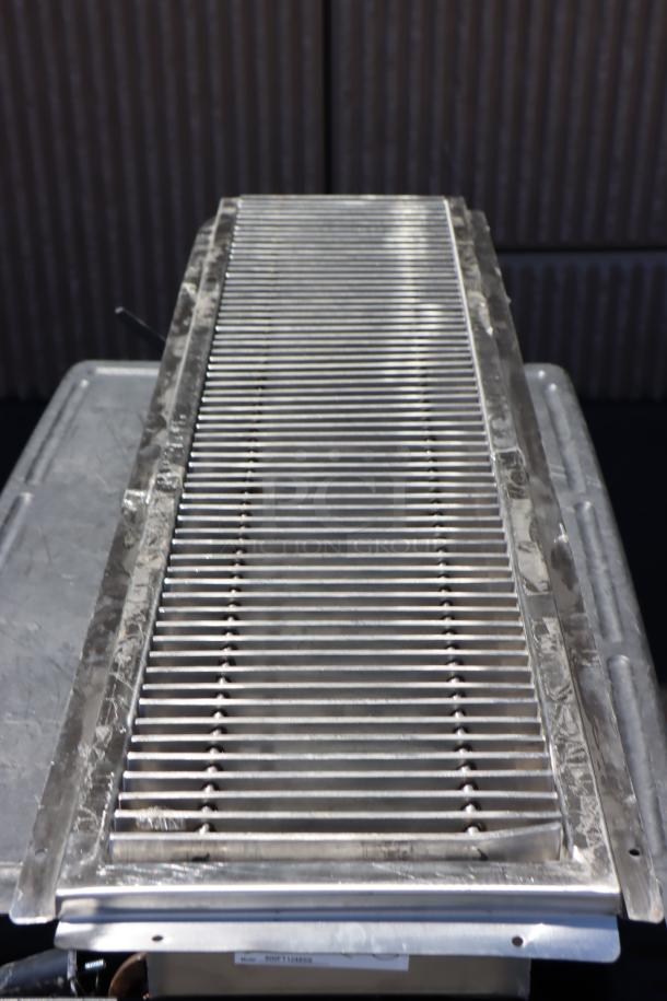 "Brand new scratch-n-dent Regency 600FT1248SS stainless steel floor trough with grate, 12x48 inches, 14-gauge."