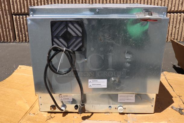 Back of Cooking Performance Group COH-D4-M countertop oven, new with minor dents. Features power cord and caution labels.