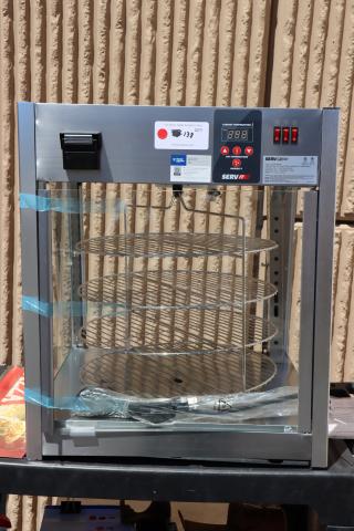 Brand new ServIt PDW18D1P pizza warmer, 18" with rotating 4-shelf and pretzel rack, broken glass pane, tags visible.