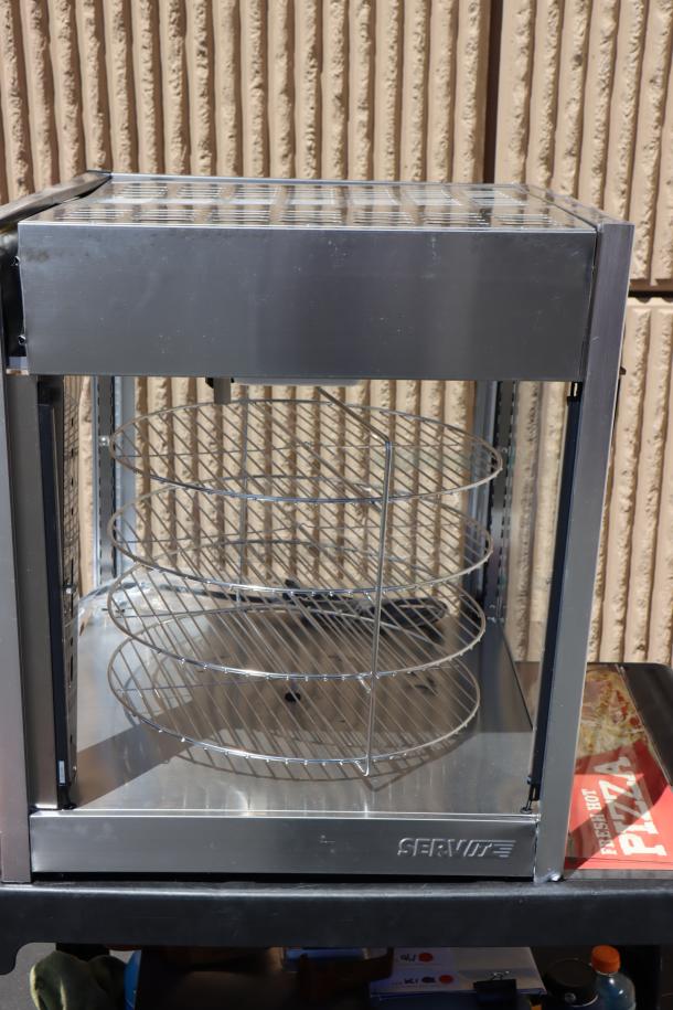ServIt PDW18D1P pizza warmer with rotating 4-shelf and pretzel rack. Glass pane is broken. Serial #1457301300066.