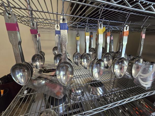 Vollrath 47055 1/8 cup stainless steel measuring scoops with purple banding, hanging on a rack. Mint condition.