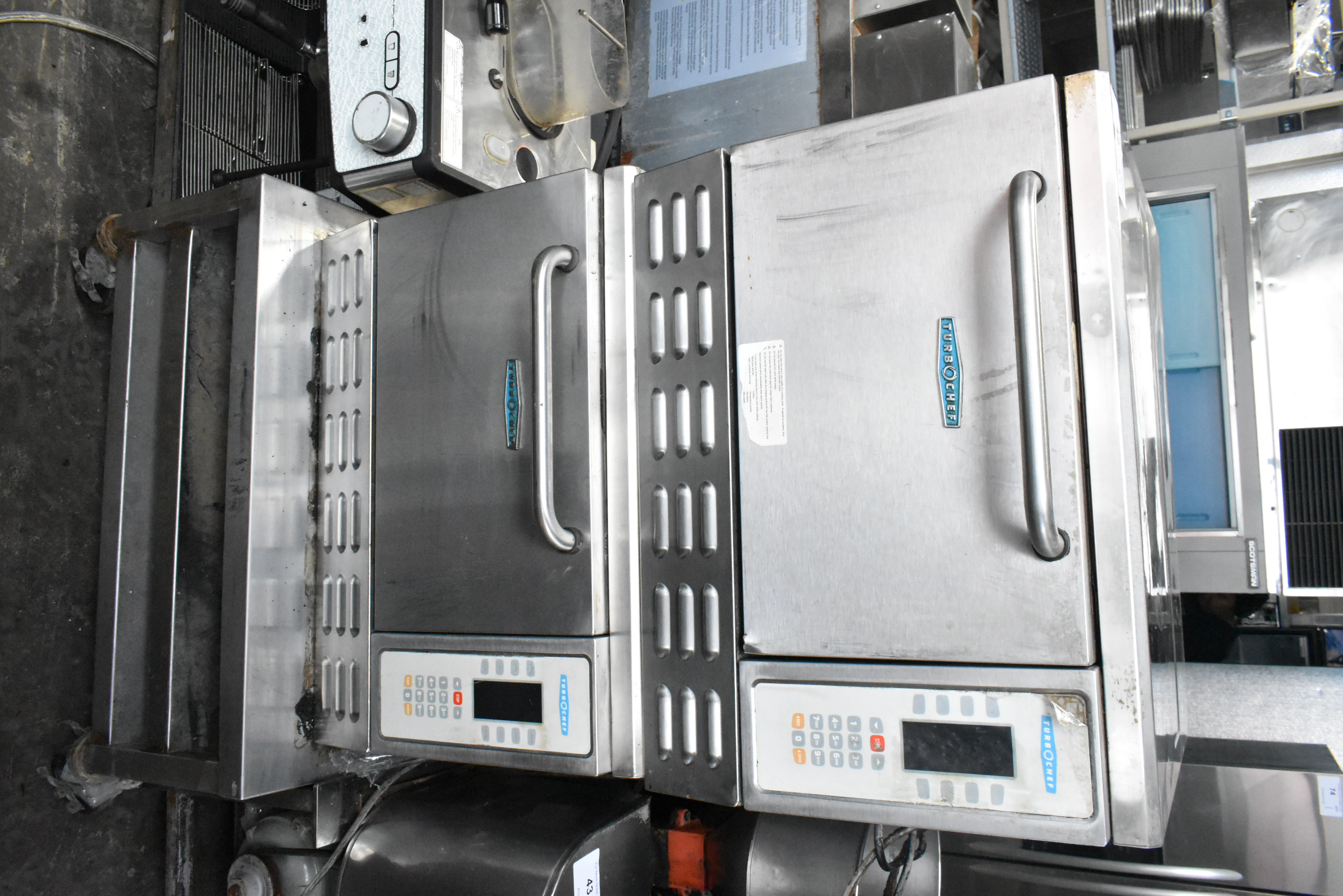 Double-stacked rapid-cook ovens on rolling cart next to espresso machine for scale
