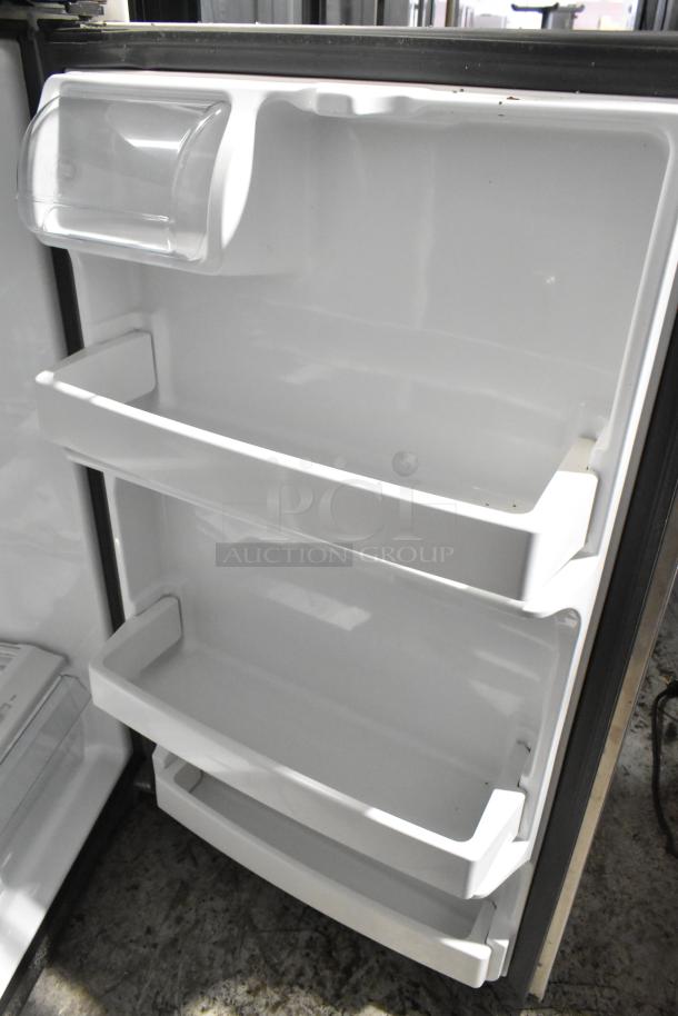 General Electric GE GTE18GSHBRSS stainless steel fridge with freezer, 115 volts, 1 phase, interior shelves visible.