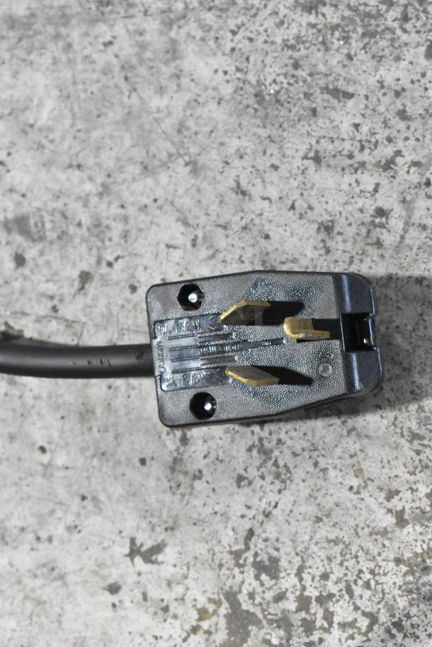 2024 Cookline 4E Gyro Machine plug detail on concrete, showing a durable 240-volt electric cord.