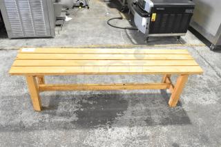 Wooden bench with slatted seat, light finish, sturdy frame. Minor wear visible, tagged with number 99. Suitable for indoor use.