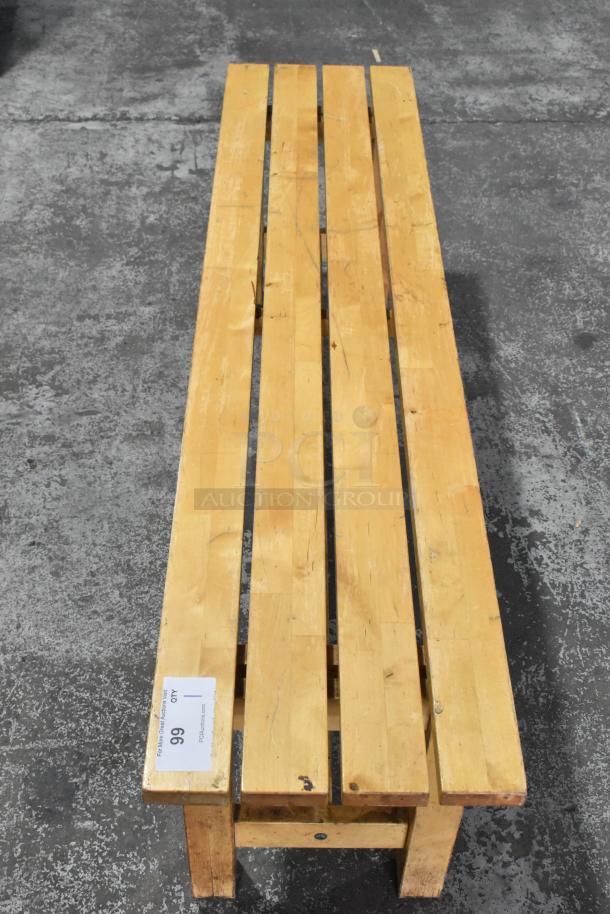 Wooden bench with a simple slatted design, light wood finish, rectangular shape. Visible tag reading "99 LOT QTY 1".