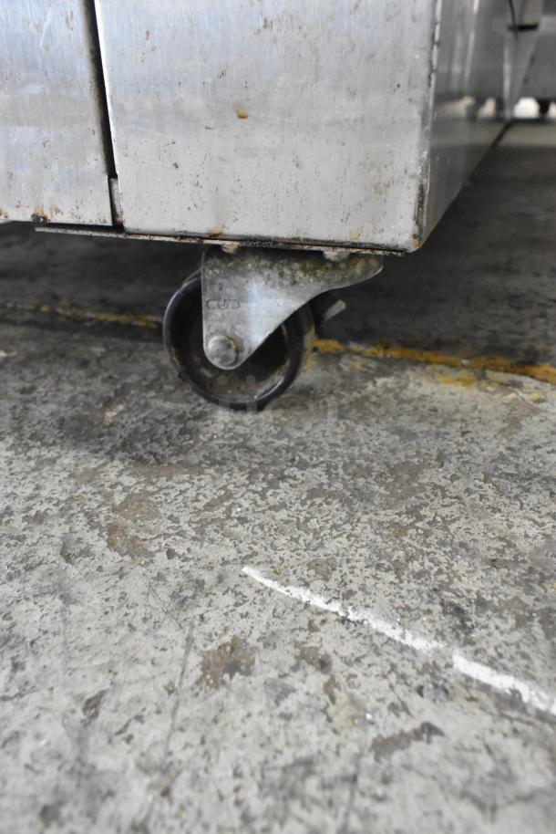 Nu Vu SUB-123 stainless steel commercial oven proofer on worn casters. Shows floor contact, 240 volts, 3 phase, model number visible.