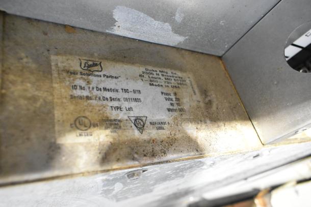 Duke TSC-6/18 stainless steel oven proofer label showing model, serial number, and voltage details.