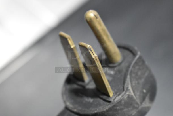 Close-up of a power plug for a Turbochef ENC Commercial Rapid Cook Oven, showing prongs and casing.