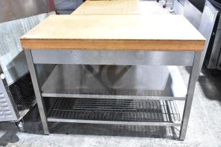 Wooden butcher block table with two under shelves, stainless steel frame, used condition, ideal for kitchens or workshops.