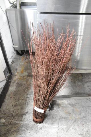 Decorative bundle of brown twigs tied with a band, suitable for home decor accents, in good condition.