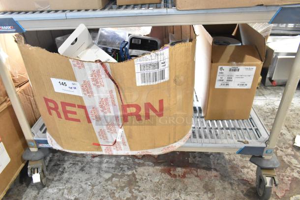 Tiered lot of assorted items including car chargers and Zebra label rolls in cardboard boxes on a cart. Condition varies.