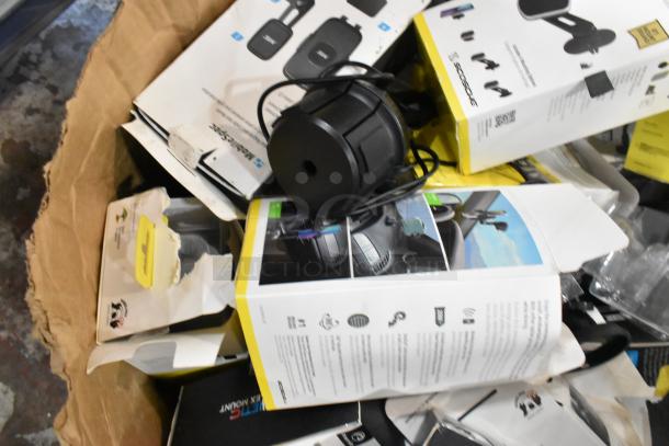 Lot of various items in a cardboard box, including multiple phone mount boxes with visible labels and packaging.