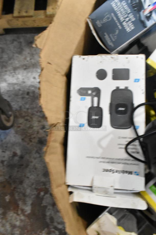 Box of assorted items, including phone mounts, in an open cardboard box. Boxes show product images and logos.