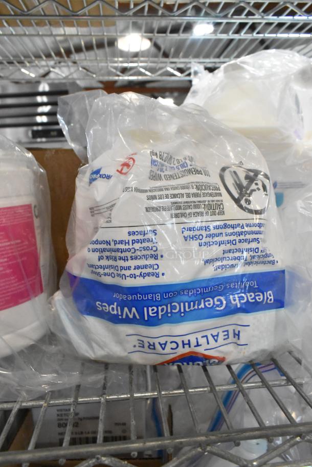 Auction lot with Diversey dry wipes, CaviWipes, and Scott Foam Skin Cleanser on a metal shelf. Includes plastic packaging.