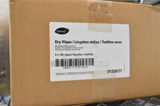 Cardboard box labeled "Diversey Dry Wipes" containing 6 packs of 100 wipes, barcode visible.