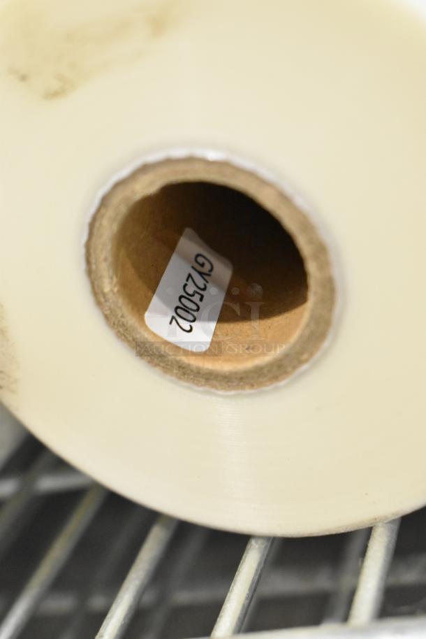 Roll of clear plastic wrap with visible label marked "GY35002" on a metal rack.