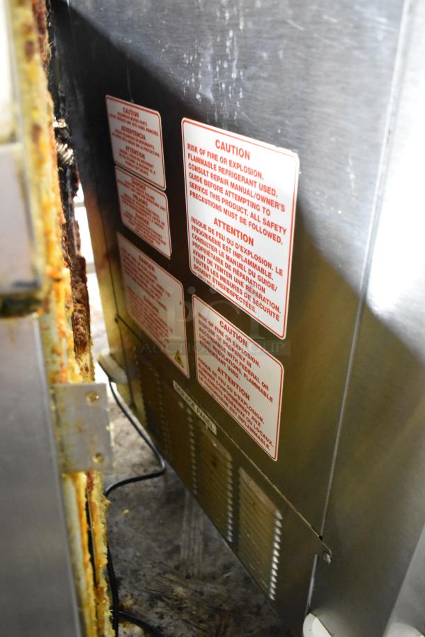 Silver King stainless steel commercial chest freezer with visible caution labels. Features 115 volts, 1 phase power, on casters.