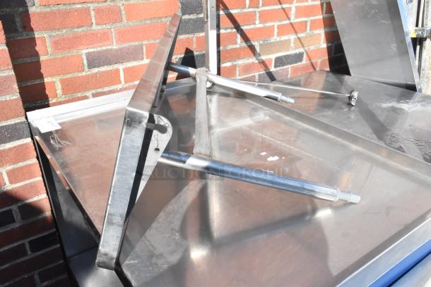 Stainless steel shelf with brackets, in good condition. Slight surface marks visible. Ideal for industrial use.