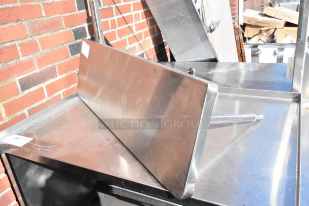 Stainless steel shelf with a polished finish, in excellent condition, featuring a small label with item details.