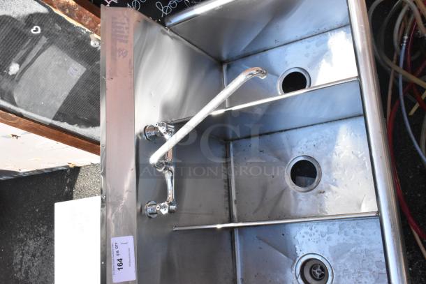 Stainless steel 3-bay sink with faucet and handles in used condition, includes drainage holes and a visible auction label.