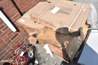 Four new scratch and dent items in boxes, including a black metal crossback chair and chrome bar frame. Boxes marked "Steelers."