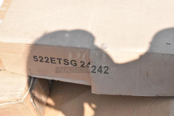 Cardboard boxes labeled "522ETSG 24242," containing new scratch and dent items, including chairs and bar frames.