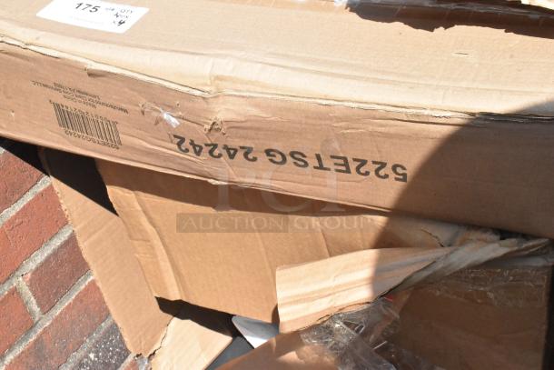 Cardboard box showing signs of damage, containing brand new scratch and dent items: Frame Chair MTL Crossback Black, Frame Bar Double Ring Chrome.