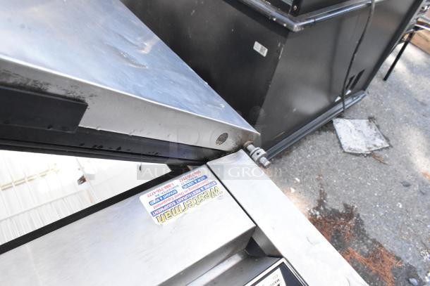 True T-49F stainless steel commercial freezer with two doors, poly coated racks, hinge detail, and visible Western tag.