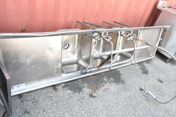 Stainless steel 3 bay sink with dual drain boards, faucet, and handles; appears in used condition.