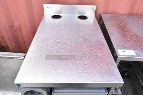 Stainless steel counter with two 4-inch cup dispensers, sleek design, minor surface marks, ideal for commercial use.