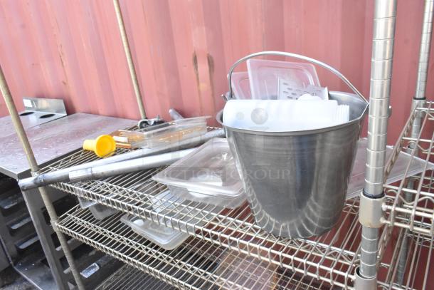 Chrome finish 4-tier wire shelving unit with assorted contents, including a metal bucket and plastic containers. Buyer must dismantle.