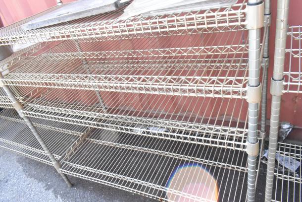 Chrome 5-tier wire shelving unit with contents, sturdy design. Buyer must dismantle. Freight charges apply.