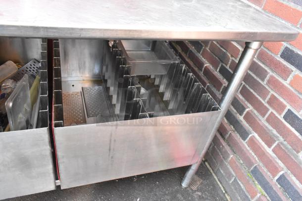 Stainless steel table with under shelf, featuring two pan racks. Good condition, suitable for kitchen storage and organization.