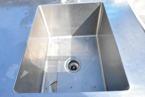 Griffin stainless steel table with single sink bay, faucet, handles, and under shelf in used condition.