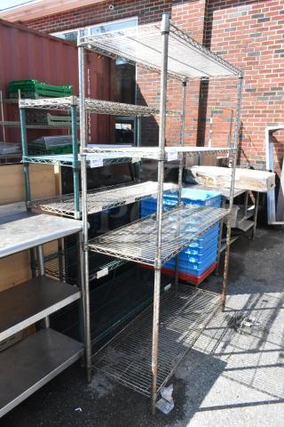 Chrome finish 4-tier wire shelving unit, industrial-style, good condition, buyer must dismantle, freight charges apply.