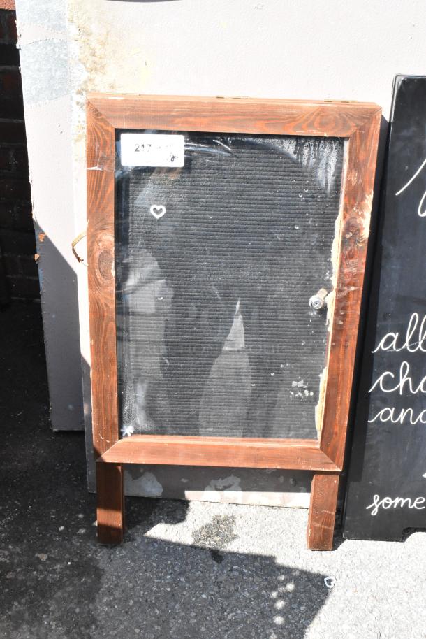 Wooden A-frame sidewalk sign with worn blackboard surface, slight weathering. Label reads "217". Multipack offer.