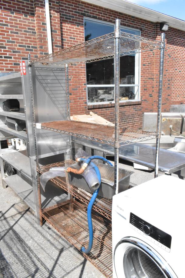 Chrome 4-tier wire shelving unit, outdoor setting, moderate wear. Buyer must dismantle for shipping; consider freight costs.
