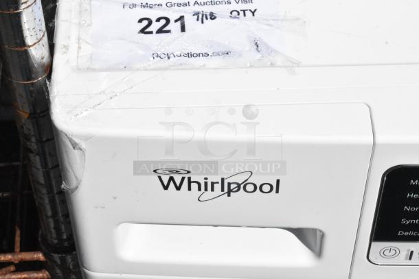 Whirlpool front load dryer, white metal, logo visible. Minor wear on corner. Auction tag attached.