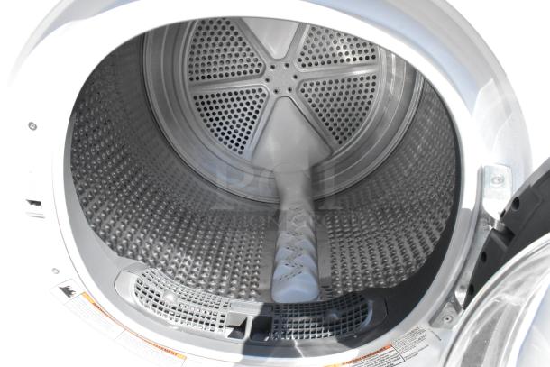 Whirlpool metal front load dryer interior, showing drum with perforated metal and lint trap. Clean condition.