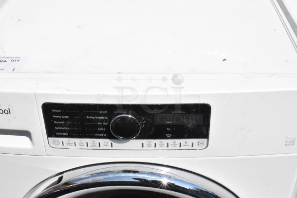 Whirlpool metal front load dryer with control panel, program settings, and minor wear visible on surface.