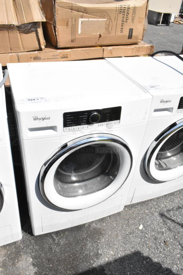 Whirlpool front load dryer, white metal, knob controls, visible wear, tags present.