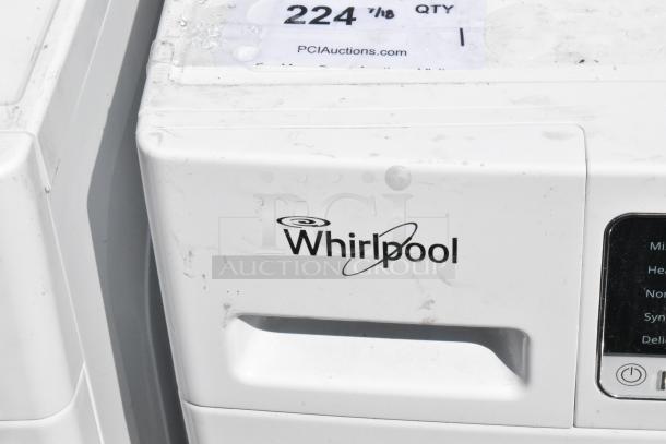 Whirlpool metal front load dryer, featuring visible control panel and Whirlpool logo. Some exterior wear. Auction label attached.
