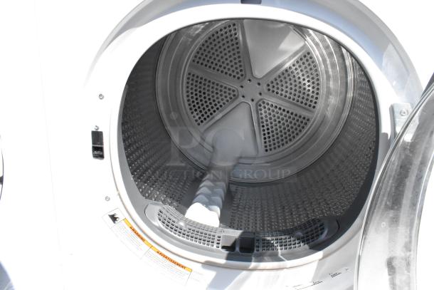 Whirlpool metal front load dryer, open door view, showing interior drum. Visible warning label. Appears in excellent condition.