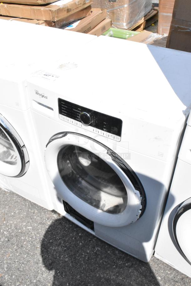 Whirlpool metal front load dryer, white, with control panel and round door. Minimal signs of wear.