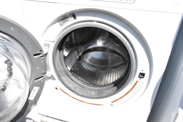 Whirlpool front load washer with open door, metal finish, model WFW5090JW0, visible label and warnings, excellent condition.