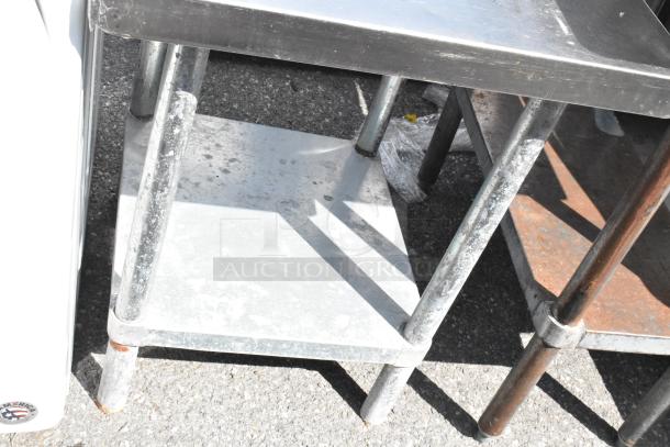 Stainless steel table with metal under shelf, used condition, sturdy construction, ideal for commercial or industrial use.