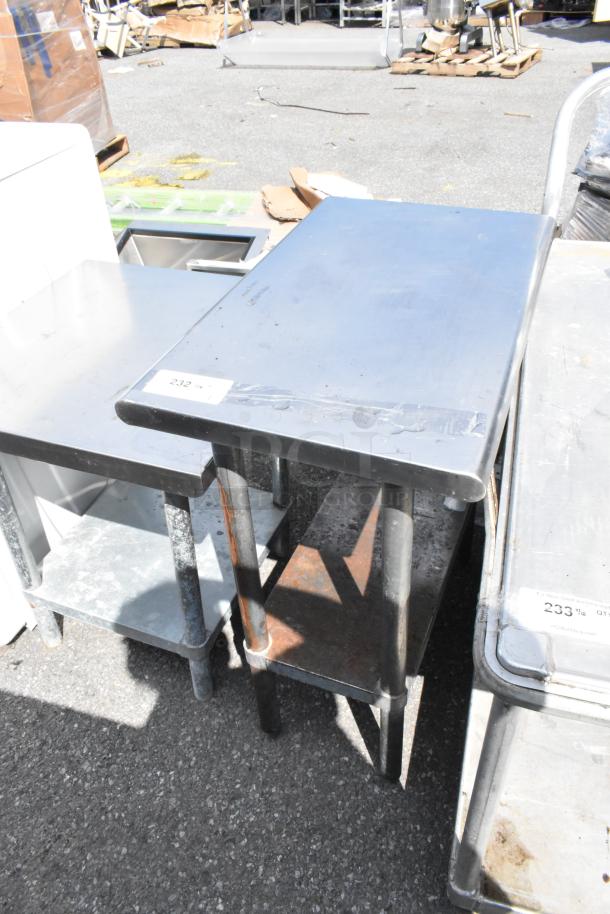 Stainless steel table with metal under shelf, showing signs of wear. Label marked "232" visible on top corner.